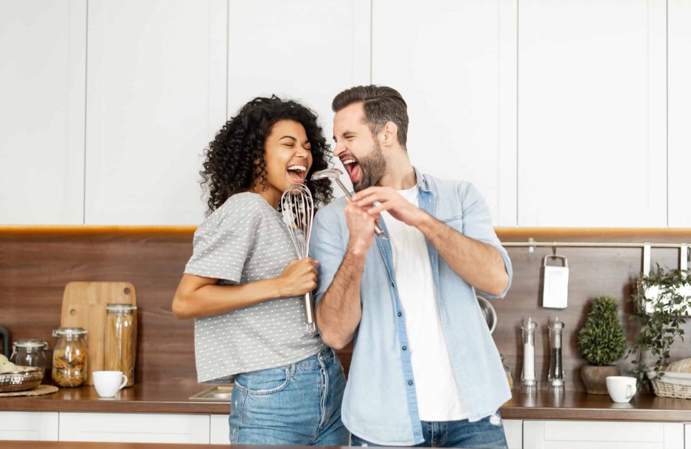 Happy,Interracial,Couple,Dancing,In,The,Kitchen,,Singing,While,Cooking