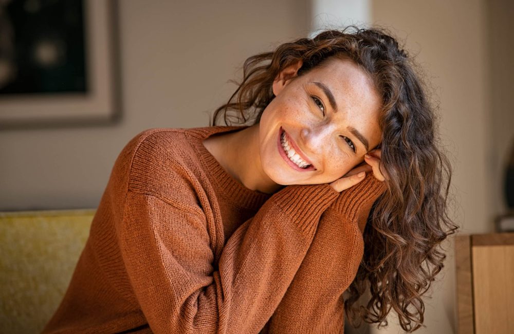 Happy,Young,Woman,Sitting,On,Sofa,At,Home,And,Looking Happy,Young,Woman,Sitting,On,Sofa,At,Home,And,Looking