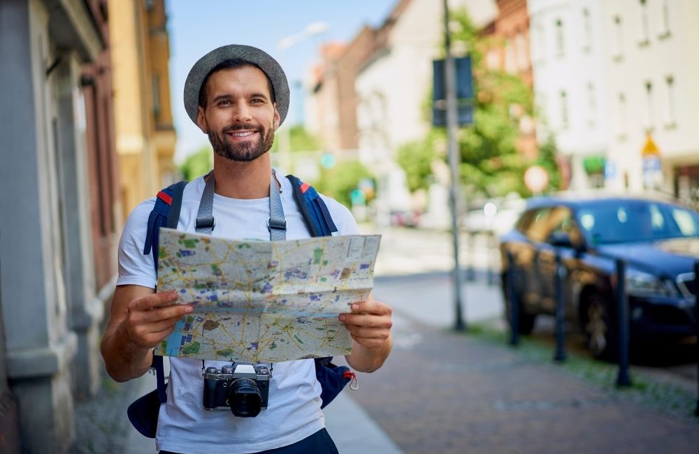 Male,Tourist,With,Map,In,Visiting,European,City,In,Summer.