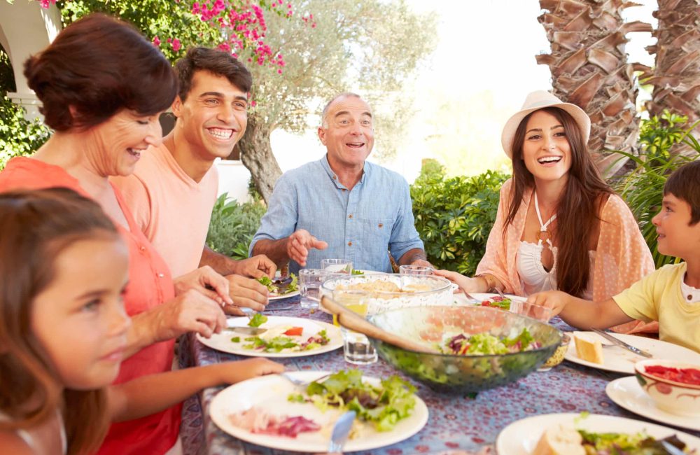 Multi,Generation,Family,Enjoying,Meal,On,Terrace,Together