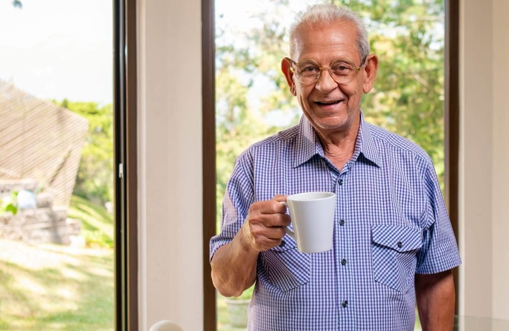 Portrait,Of,An,Elderly,Man,Drinking,Coffee,In,Front,Of