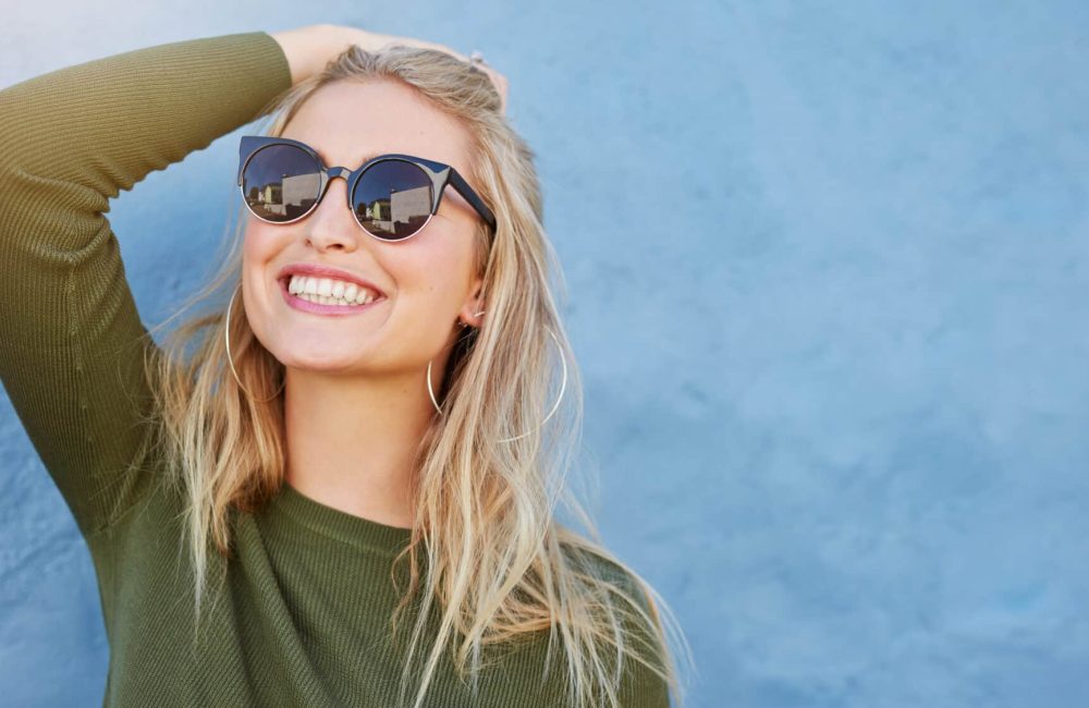 Close,Up,Shot,Of,Stylish,Young,Woman,In,Sunglasses,Smiling